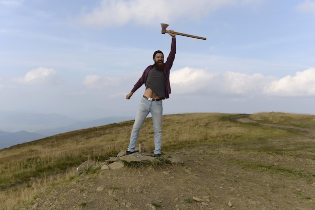 Homem barbudo com machado na montanha