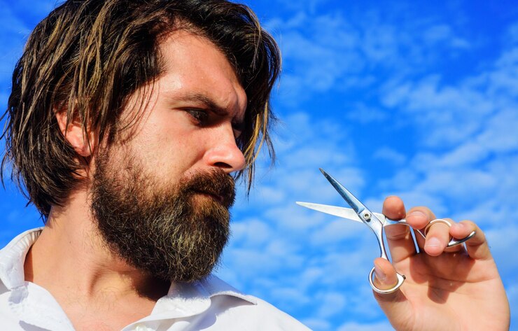 Foto homem barbudo com tesoura de barbeiro estilo de barba profissional e corte de cabelo masculino na barbearia