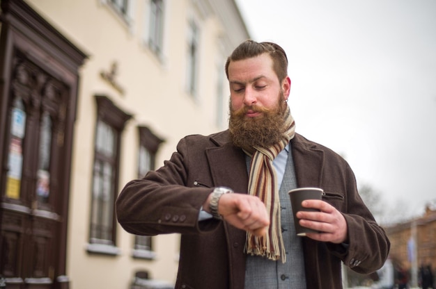 Homem barbudo com um copo de café