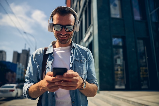 Foto homem barbudo com um sorriso no rosto enquanto conversa online com seu amigo