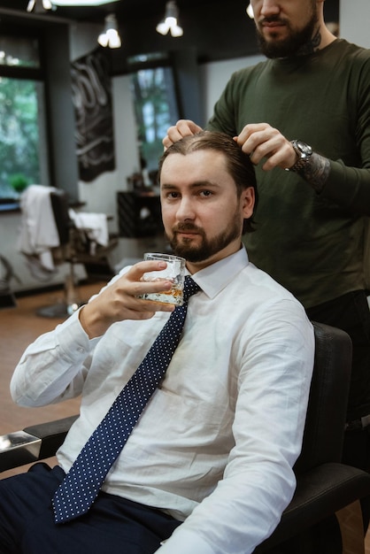 Homem barbudo cortando a barba na barbearia