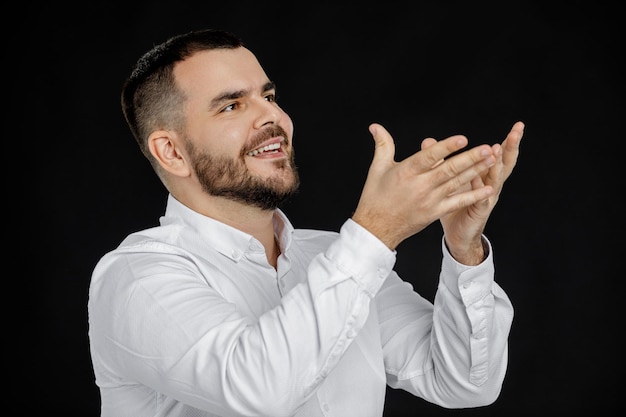 Homem barbudo de camisa branca dizendo algo