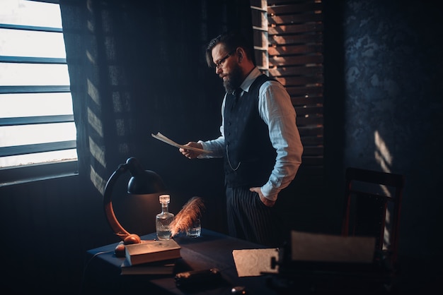 Homem barbudo de óculos lendo texto manuscrito