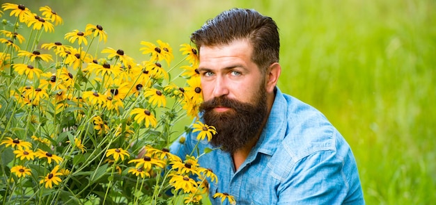 Homem barbudo despreocupado, unidade de flores de primavera ao ar livre com campo e prado naturais