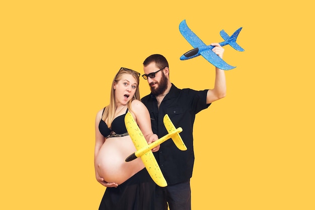 Homem barbudo e garota grávida estão segurando aviões amarelos e azuis o conceito de uma proteção pacífica do céu contra ataques aéreos