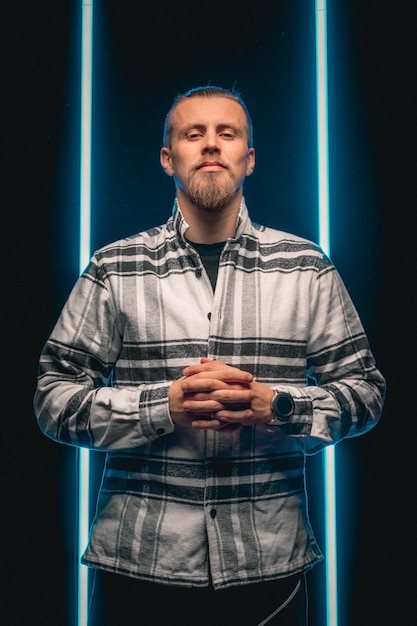 Foto homem barbudo em camisa xadrez em fundo neon preto