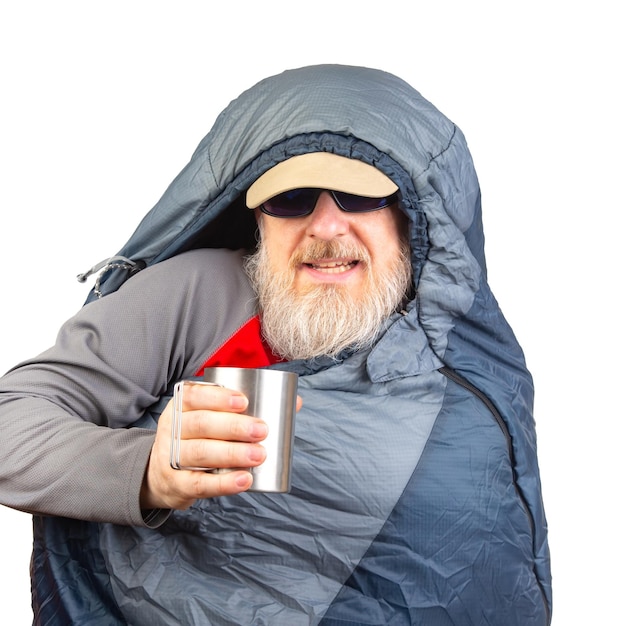 homem barbudo em um saco de dormir com uma xícara de café em um equipamento de fundo branco