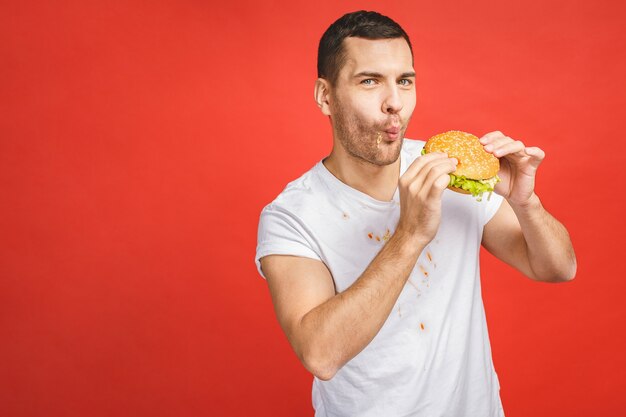 Homem barbudo faminto e engraçado comendo junk food