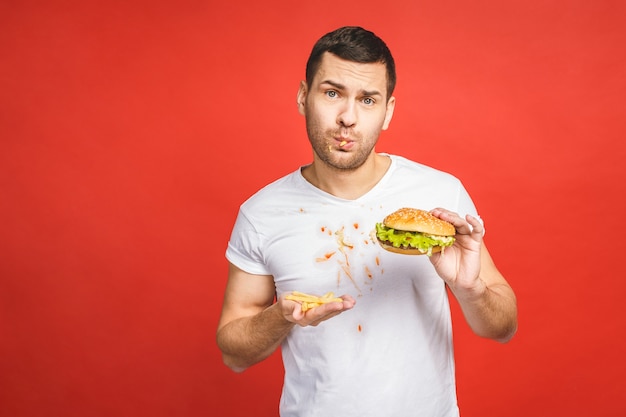 Homem barbudo faminto e engraçado comendo junk food