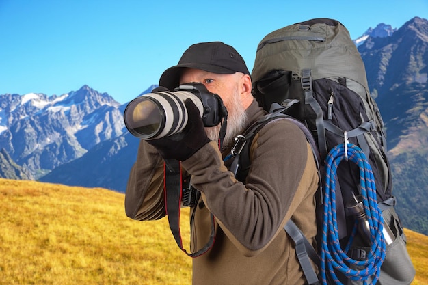 Foto homem barbudo fotógrafo turístico com uma mochila fotografa a beleza da natureza