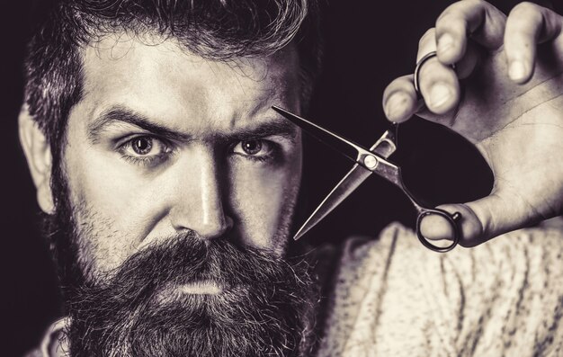 Foto homem barbudo, homem barbudo. retrato de barba de homem elegante. tesouras de barbeiro e navalha, barbearia. barbearia vintage, barbear-se. preto e branco.