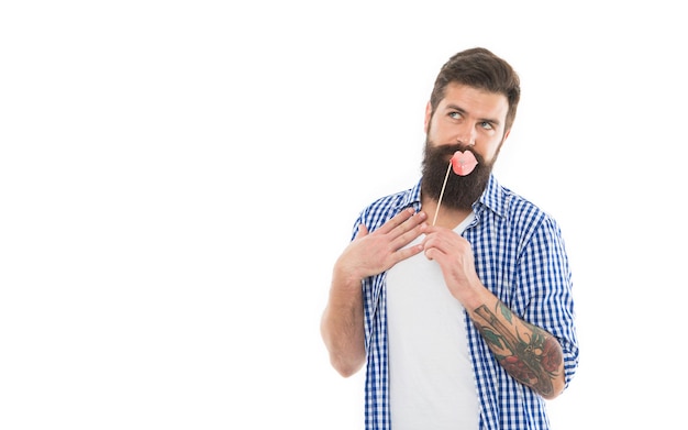 Homem barbudo lúdico com aparência coquete tirando sarro com adereços de festa para os lábios photobooth