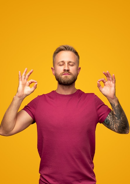 Homem barbudo meditando com os olhos fechados