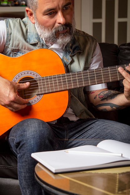 Homem barbudo moderno tendo aulas de violão online. Conceito de aprendizagem online.