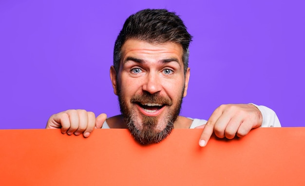 Homem barbudo sorridente com placa de sinal em branco de banner publicitário vazio com espaço para texto ou produto