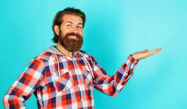 Homem barbudo sorridente mostra algo na palma da mão com espaço de cópia para desconto de publicidade de produtos