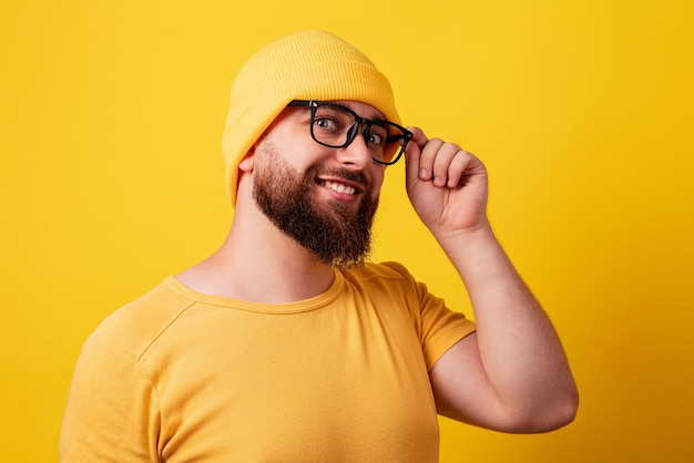 Foto homem barbudo sorridente sobre fundo amarelo