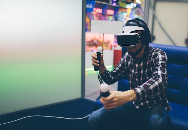 Foto homem barbudo usando óculos de realidade virtual em coworking moderno smartphone usando com fone de ouvido vr. horizontal, desfocado.