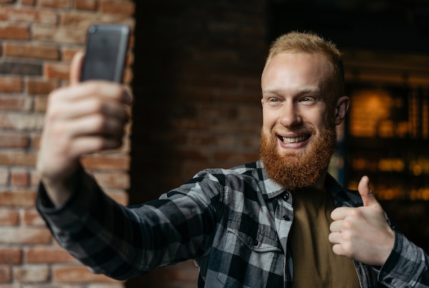 Homem barbudo usando telefone celular, tirando selfies