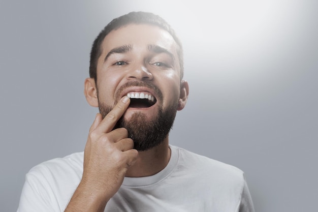 Homem barbudo, verificando o estado de saúde dos dentes