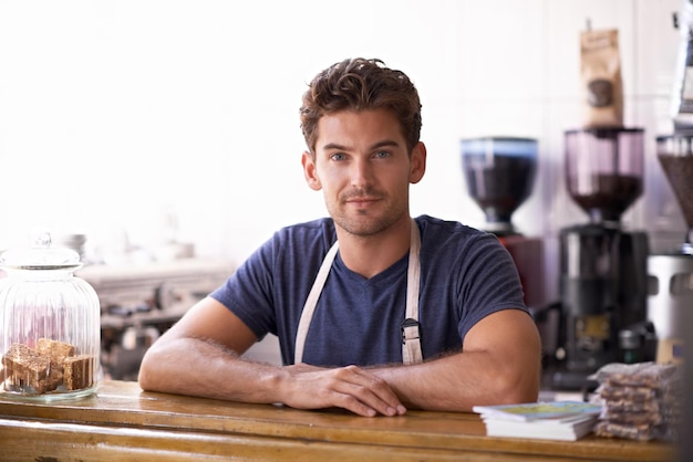 Homem barista e retrato em balcão de café e trabalhando em restaurante ou pequeno negócio Homem empresário e profissional em bistro confiança e orgulho na carreira e hospitalidade