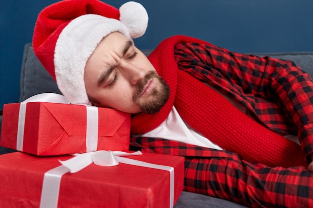 Homem bêbado dormindo em presentes de Natal
