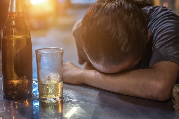 Homem bêbado dormindo no balcão de bar | Foto Premium