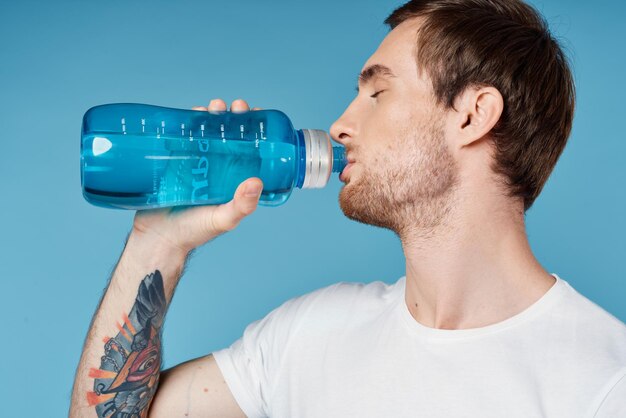 Homem bebendo água de garrafa azul exercícios de fitness sede foto de alta qualidade