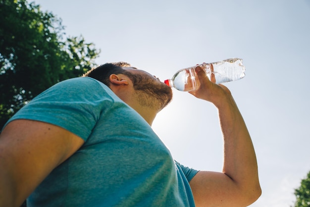 Foto homem bebendo água em um dia quente de verão copiar espaço