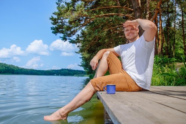 Homem bebendo café com bela vista para o lago