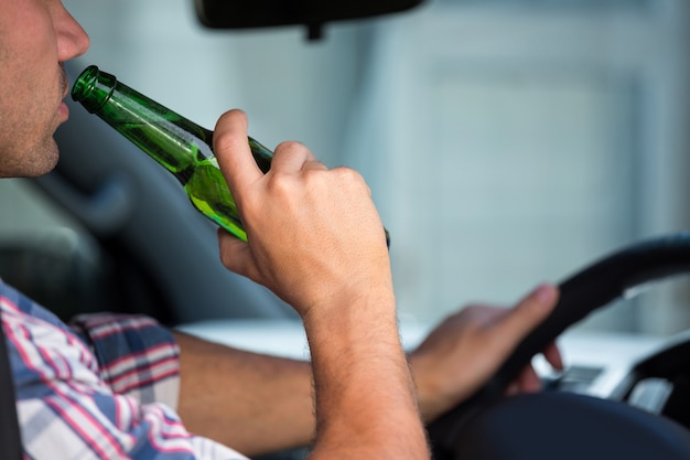 Foto homem bebendo cerveja enquanto dirige