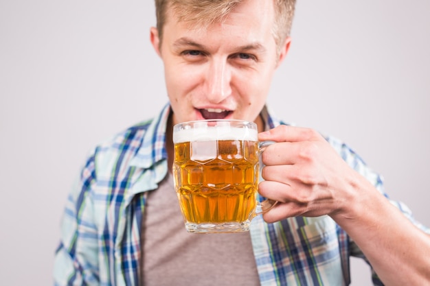 Homem bebendo cerveja. jovem feliz segurando uma caneca de cerveja.