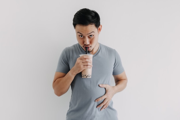 Homem bebendo chá de boba ou chá de bolhas deliciosamente isolado no fundo branco