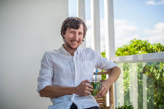 Homem bebendo um mojito no terraço