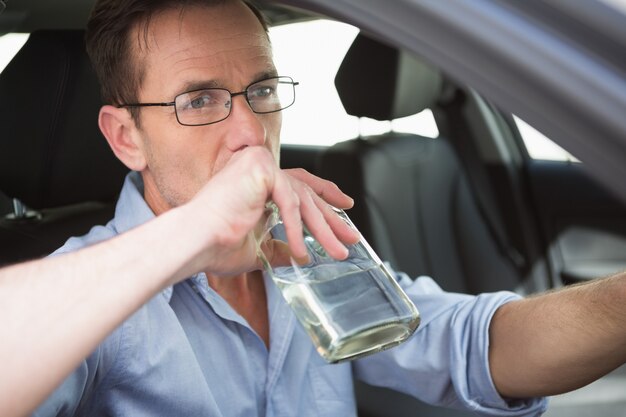 Homem bebendo vinho enquanto dirige