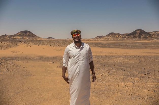 Homem beduíno vestindo roupas tradicionais no deserto do Saara, deserto negro em Bahariya, Egito