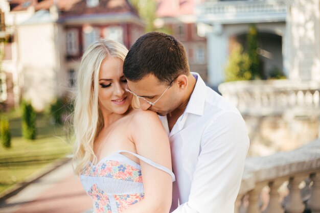 Homem beija os ombros da mulher, casal apaixonado