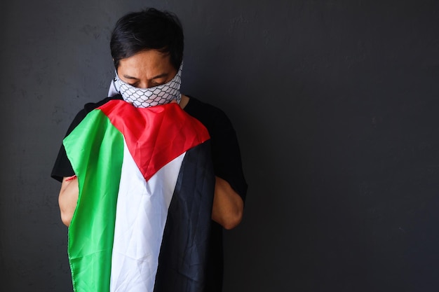 Foto homem beijando uma bandeira da palestina como símbolo de apoio