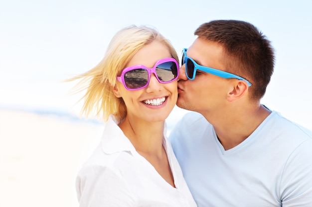 homem beijando uma mulher na praia