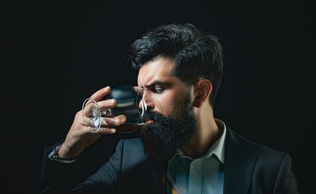 Foto homem bem vestido confiante com copo de uísque barbudo e copo de uísque