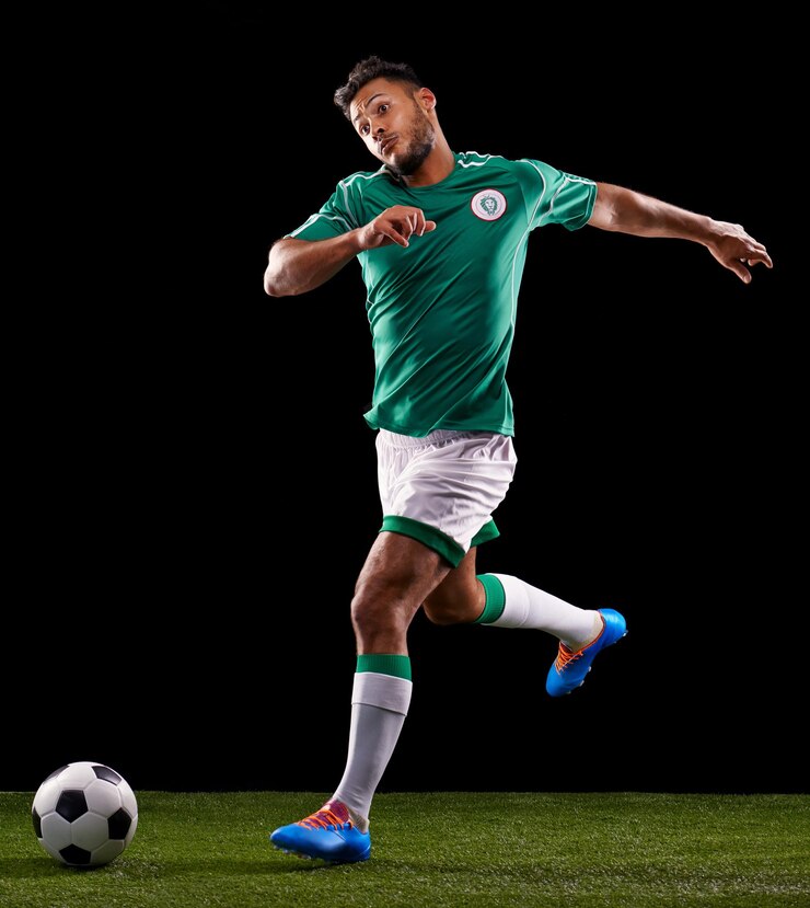 Foto homem bola e futebol para o esporte e aptidão para o jogo ativo e roupas esportivas em grama ou campo modelo de atleta ou jogador e prática para chutar competitivo e marcar à noite em fundo escuro
