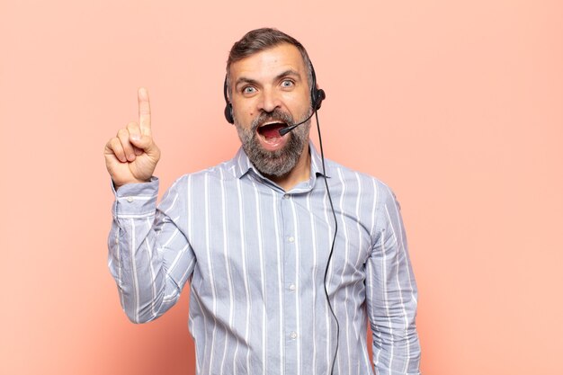 Homem bonito adulto se sentindo um gênio feliz e animado depois de realizar uma ideia, levantando o dedo alegremente, eureka!