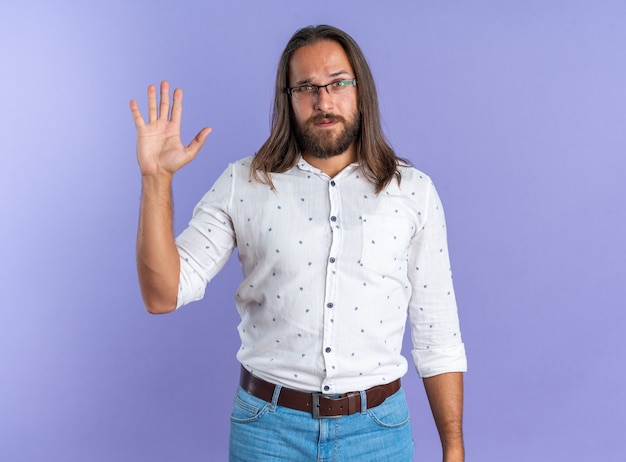 Homem bonito adulto sério usando óculos, mostrando a mão vazia