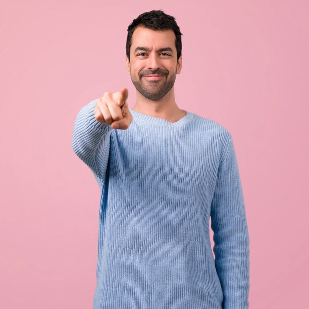 Homem bonito aponta o dedo para você no fundo rosa