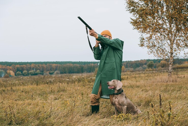 Foto homem bonito, apontando para o pássaro com uma arma