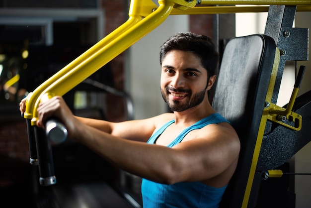Homem bonito asiático indiano malhando ou se exercitando na academia - conceito de saúde e fitness