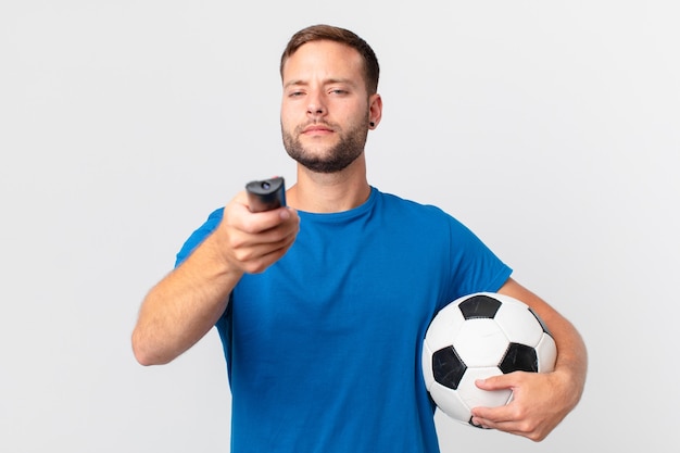 Homem bonito assistindo futebol na televisão