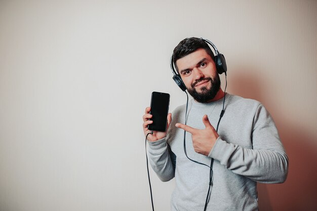 Homem bonito barbudo em fones de ouvido, homem ouvindo música