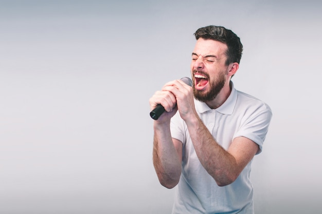 Foto homem bonito cantando ao microfone