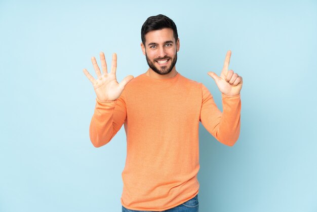 Homem bonito caucasiano contando sete com os dedos isolados